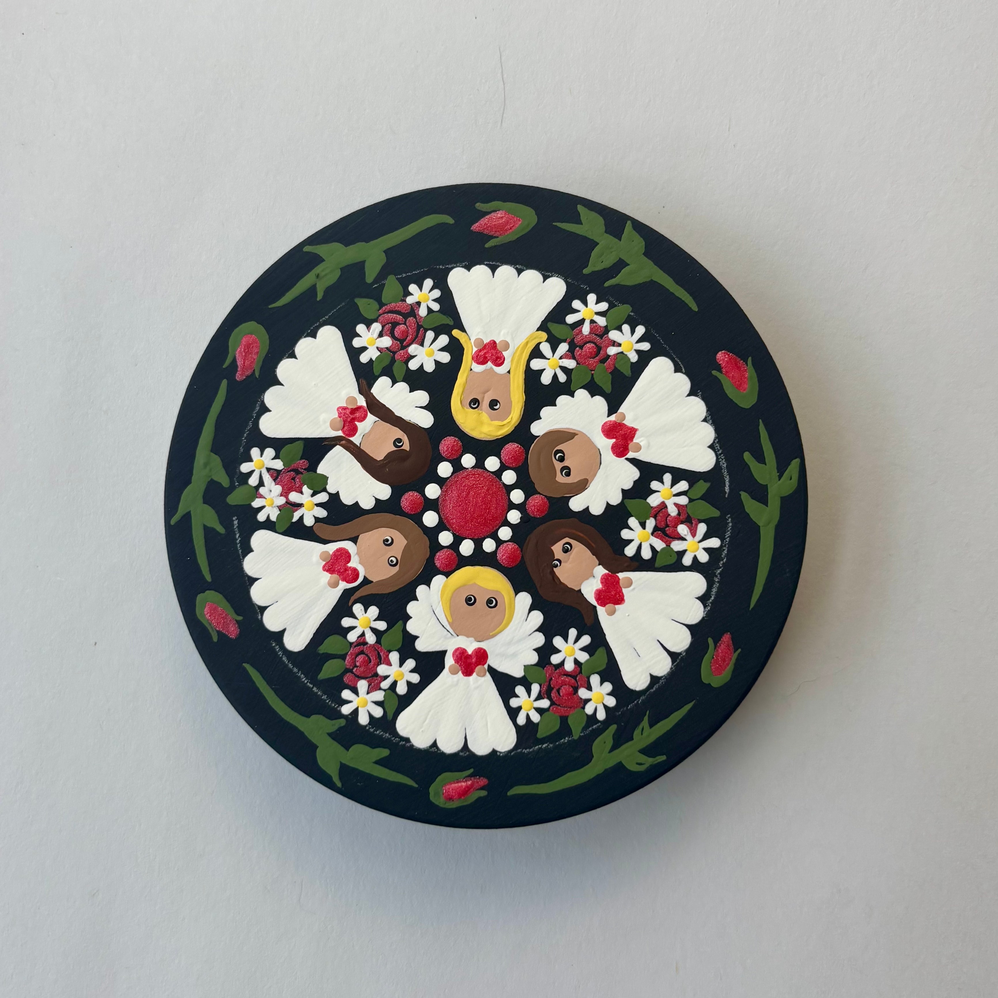Decorative circular plate with folk art figures and floral mandala design