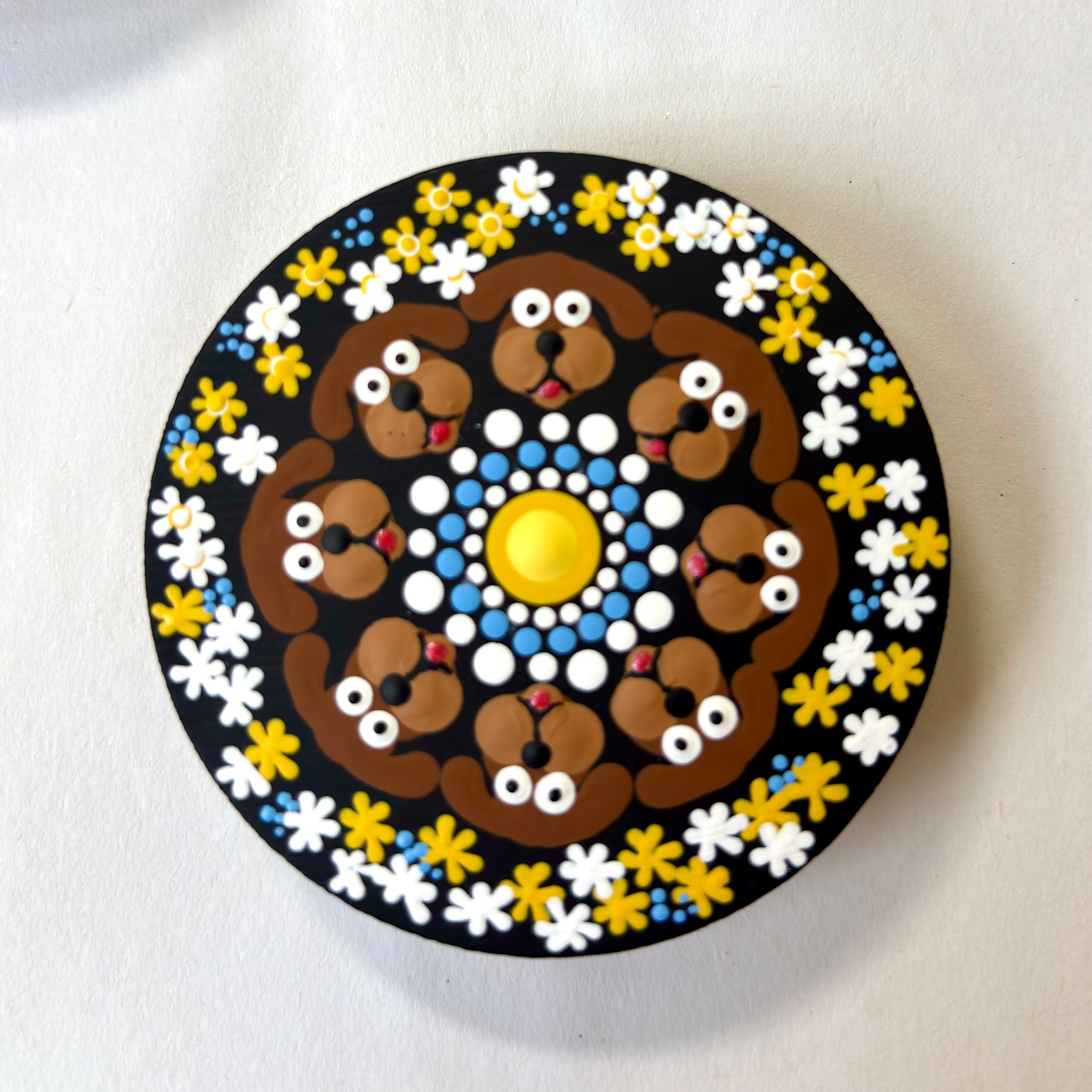 Handcrafted circular plate with dog faces arranged in a mandala pattern