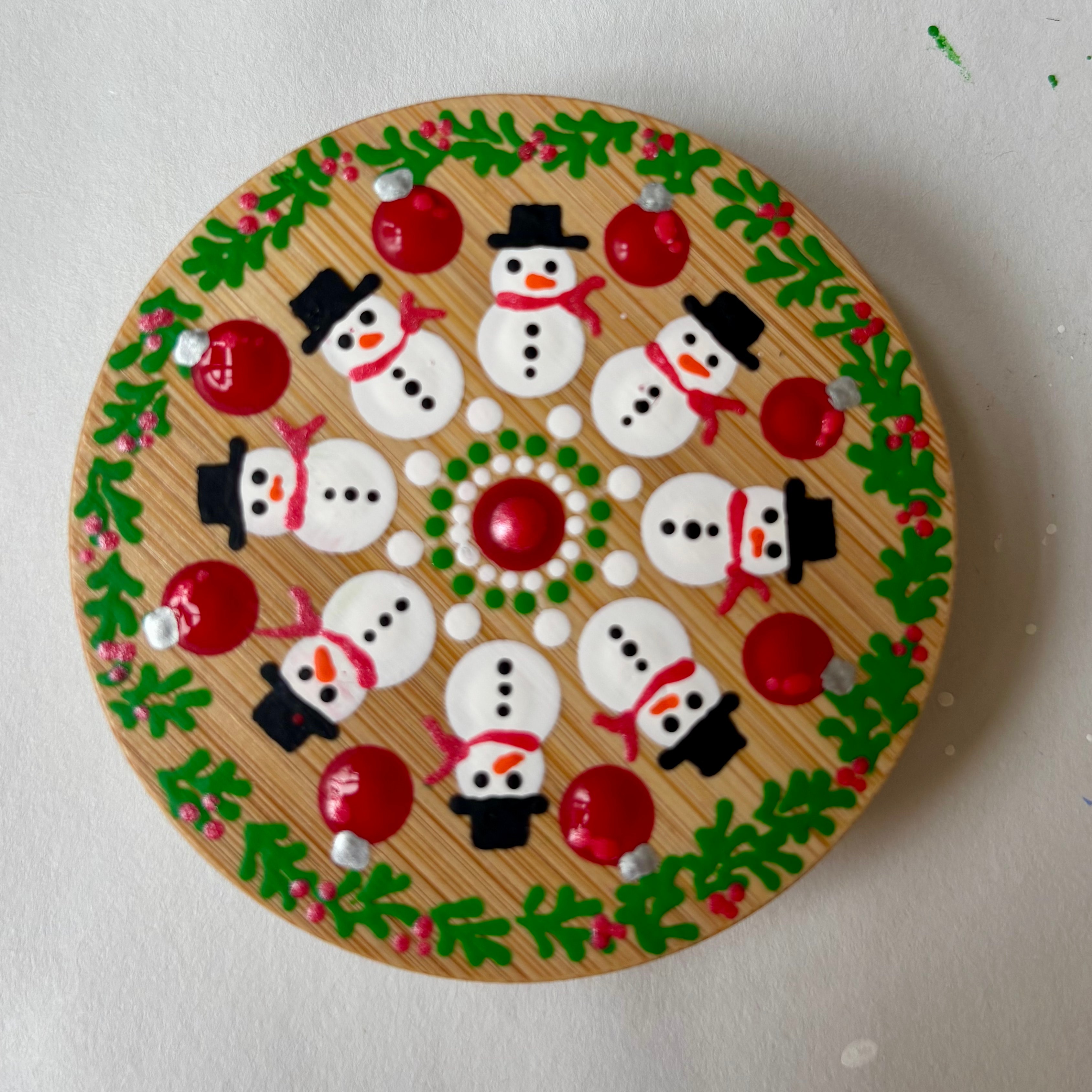 Festive wooden ornament with hand painted snowmen and holiday design